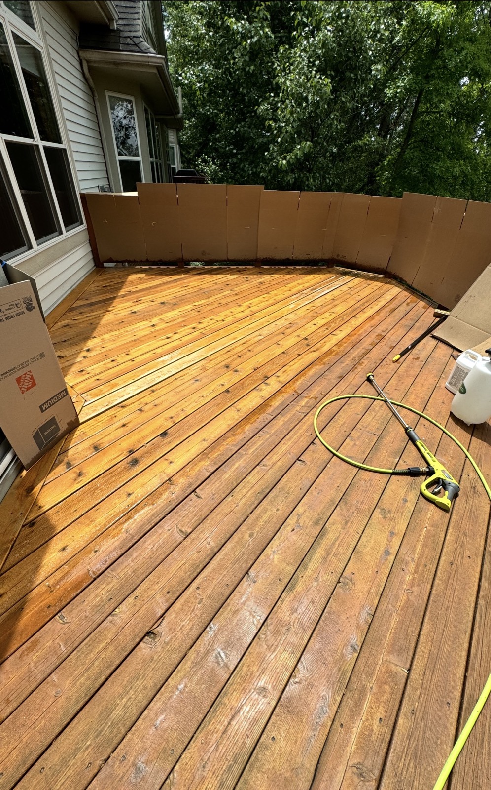 Deck pressure washed and prepped for stain, with the railing protected